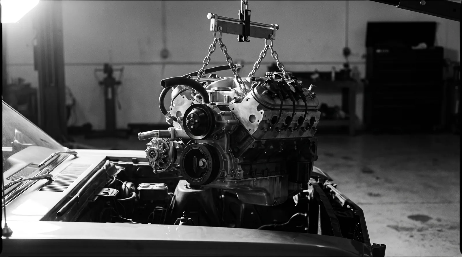 Reconditioned engine on a load leveller being lowered into an engine bay